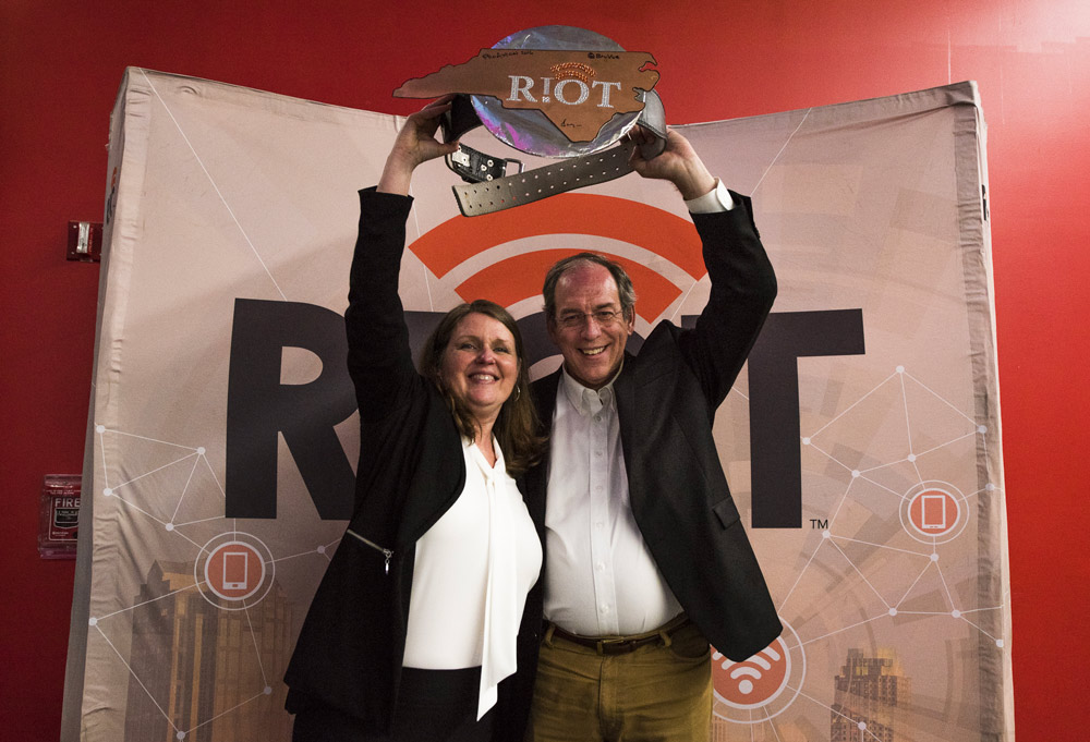 a man and woman accept an award at the RIoT Accellerator Program